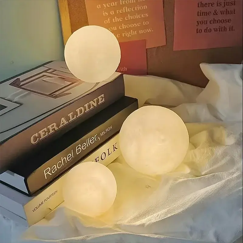 GLOBGRIP Book Light LED Moon Galaxy Night Light set glowing next to books on cozy fabric